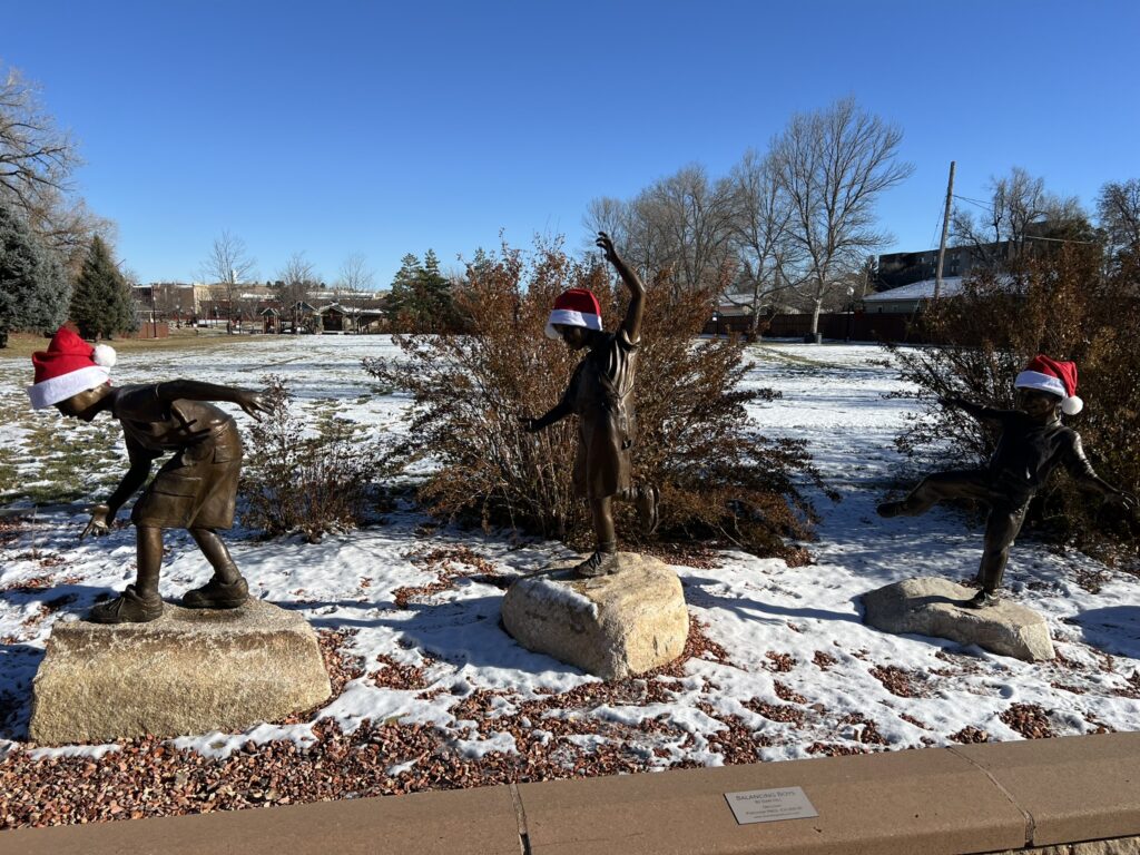 Balancing Boys Statue at Whitney Commons with Holiday Hats.